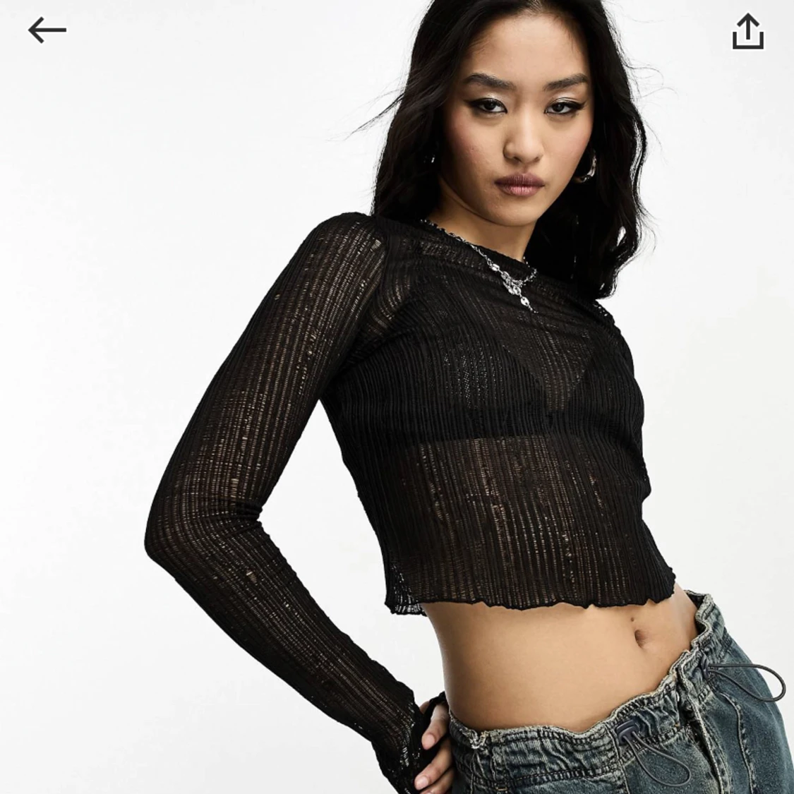 Svart topp med långa ärmar och hålstickad textur