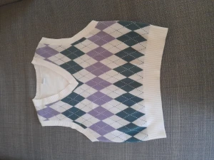 Vit väst! - En vit väst med lila/grönt mönster! Västen är i jätteskönt och mysigt material, använd ett par gånger!