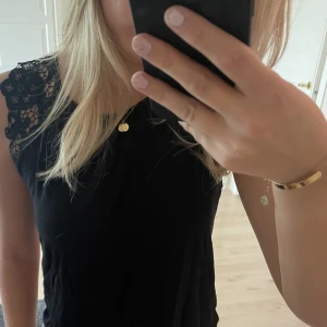Svart topp - En topp med lite spets på sidorna vid axlarna. Använd fåtalgånger! 