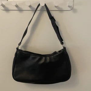 Handväska Svart - Svart handväska från Monki i bra skick. Fake läder och 17 cm på bredden. 