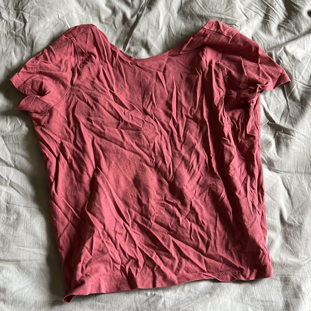 Gammalrosa T-shirt som är låg i ryggen. Fint skick. Som man ser behöver den strykas 😅. Toppar.