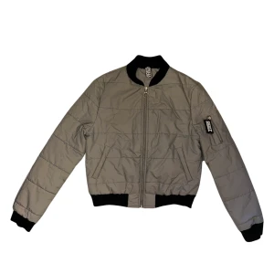 JACKA - Bomberjacka i reflex med orange foder. Märkt uk 8 och passar xs-s. Mycket sparamt använd då den är för liten för mig. Kan skicka fler pics om det önskas! 