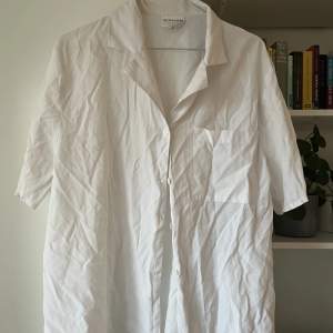 En stor, luftig vit skjorta som är perfekt att slänga över en bikini eller ett linne🤍