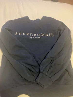 marinblå abercrombie tröja - -marinblå tröja från abercrombie & fitch, storlek S -nypris 480kr -sparsamt använd och i fint skick, men lite noppig därav priset.