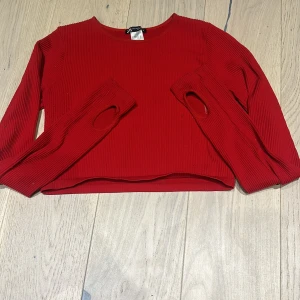 Långärmad tanktopp❤️❤️ - Kort röd topp med långa ärmar. Ärmarna har hål för tummar och tröjan är i stretchigt ribbat tyg.😍 Den är i storlek M-L men sitter tajt på XS-S och är kort.❣️Perfekt om du gillar cropade tröjor!! Skriv för bild när den sitter på❤️❤️