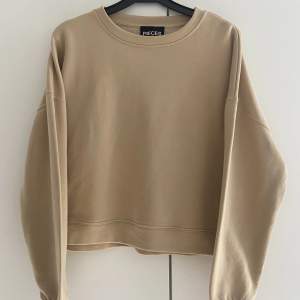 En fin, helt oanvänd sweatshirt från Pieces i beige färg. Storlek M.