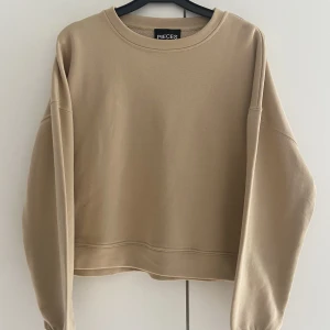 Sweatshirt beige - En fin, helt oanvänd sweatshirt från Pieces i beige färg. Storlek M.