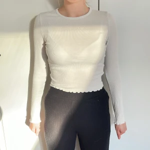 Vit långärmad tröja med öppen rygg - Vit, långärmad, ribbad tröja. Öppen rygg, se bild. Storlek S. Bra skick! Modellen bär vanligtvis storlek S och är 168cm