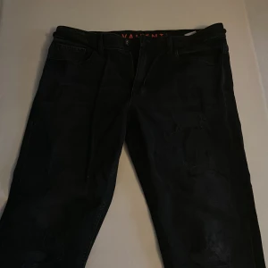Svarta vailent jeans  - Snygga svarta jeans med slitningar, slitningarna är menade att vara på jeansen 