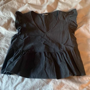 Topp - Svart topp med volang i bra skick, 50+frakt