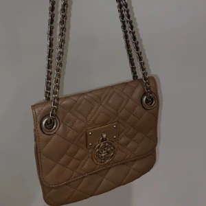 Guess brun väska - ❗️priset kan diskuteras❗️En super fin Guess Aliza converible crossbody Brown msrp. Har haft den i några år men knappt använt den. Det går att justera bandet. Originalpriset låg på ca 1500kr. Mått: 22 x 19 x 9,5 cm Handtagshöjd: 27 cm