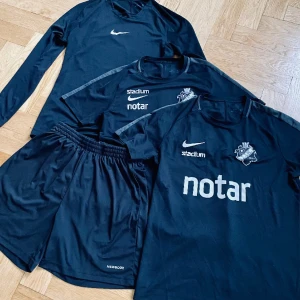 Träningsset Nike för män/ungdom - Träningsset Nike med Dri-fit-funktion bestående av:  2 kortärmade tröjor, stlk M och S  1 långärmad tröja, stlk M  Shorts Newbody, stlk S/M 
