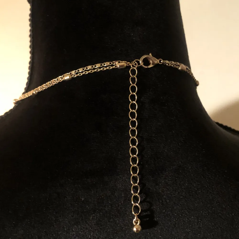Guld halsband med dubbla kedjor. Hängena har två olika tryck. Längd ca 49cm. Vikt ca 12g.. Accessoarer.