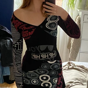 Desigual klänning - Mönstrad långärmad klänning. Enda defekten är ett litet hål som enkelt kan sys ihop. Asymmetrisk och jättefin på. 