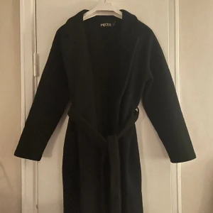 Svart kappa - Säljer min jätte snygga kappa, den mellan lång kappa och i ny skick, använd två gånger. Trendig och passar till allt💕Passar perfekt till hösten,vintern och våren. Den håller värme väldigt bra!