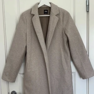 Beige kappa zara - Beige kappa från zara  Använd, lite nopprig i tyget. Se bild.  Stl M  100% polyester