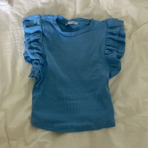 Zara topp med volang - Säljer denna jättesöta topp från zara! Använd några få gånger men i bra skick utan några somhelst fläckar! Storlek S❤️❤️