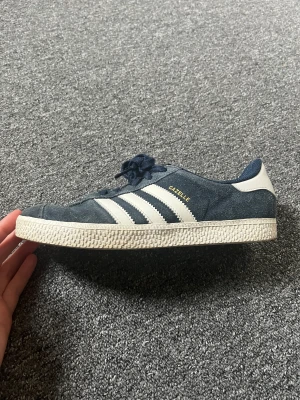 Adidas gazelle - Ett par mörkblå adidas gazelle. De är använda en del så därav det låga priset, men fortfarande jättefint skick! Storlek 35,5 men stora så passar även 36-36,5