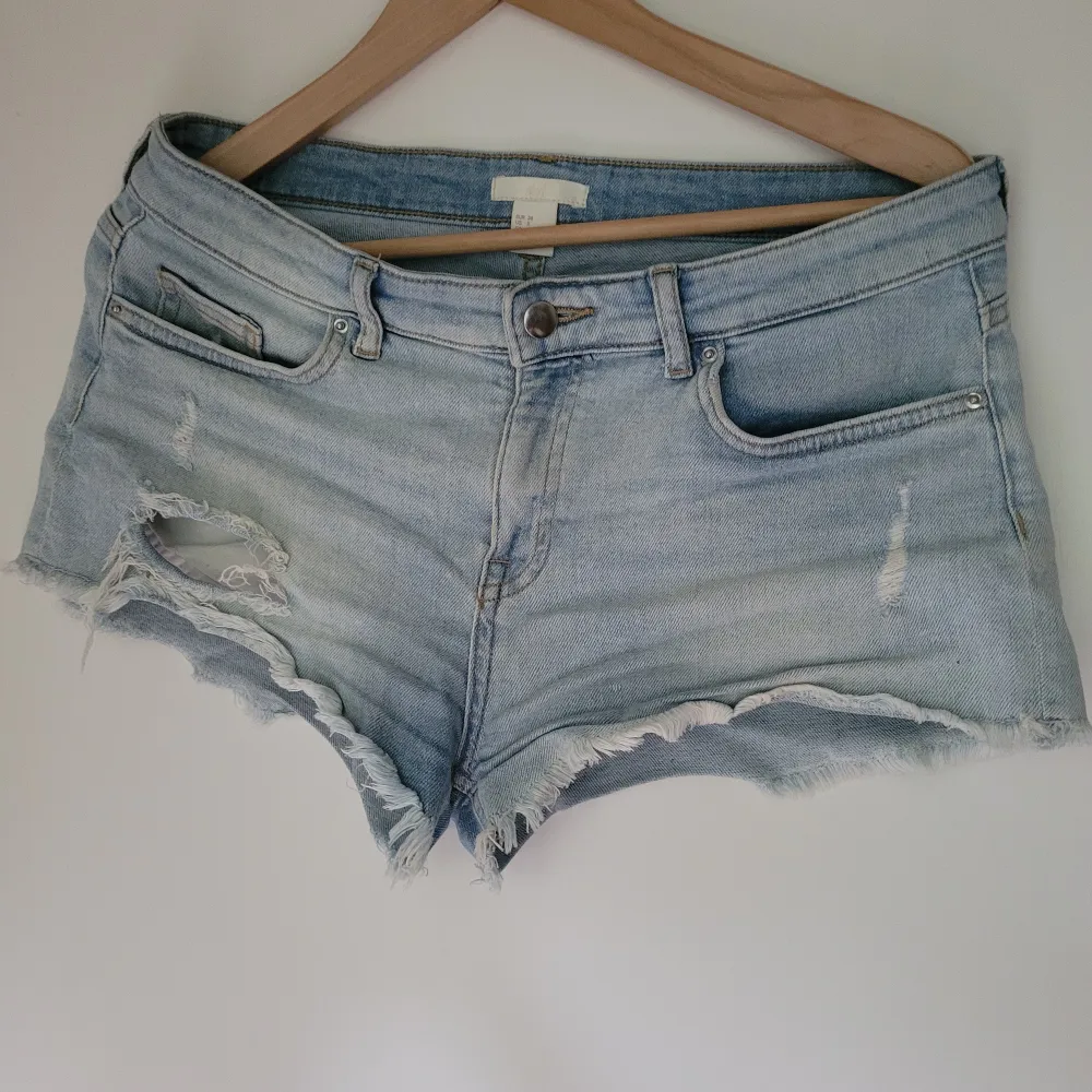 Jättesnygga, lågmidjade trendiga korta jeansshorts, fransiga nertill och med slitningar/hål. Ljus fin färg! H&M stl.38. . Shorts.