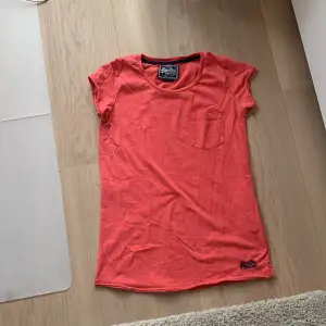 En röd vintage T-shirt från SuperDry med en liten ficka på framsidan. Säljer för att den inte används.🫶🏼