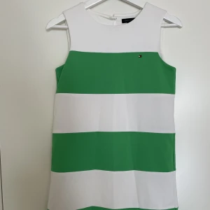 Randig klänning  - Säljer denna eleganta klänning som jag har  använt på skolavslutning och middagar. Tyvärr för liten för mig nu. Barnstorlek XL som ska passa 16 åringar. Kan passa en xxs. Klänningen har tjockt fint tyg med guldiga knappar bak. 