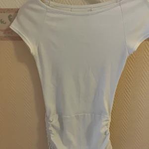 En lång vit tröja med snören - En lång vit tröja med snören, bra skick, Sotorlek S.