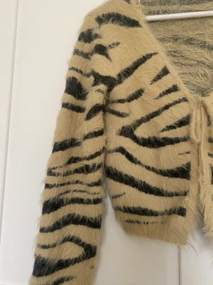 Kofta i lent fluffigt tyg - Oanvänd på grund av hade en likadan tröja redan i annan form.  Fint mönster varm och len perfekt att ha över klänning eller till linne under sommaren 