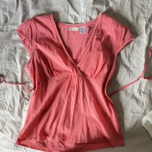 Topp - Underbar topp i korallrosa färg med band som knyts i ryggen. Passar en S-M. 