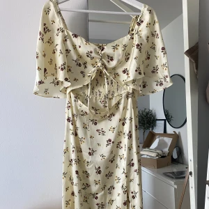 Blommigklänning Zara - Superfin klänning från Zara med knytning framtill och slits vid benet. I ett super mjukt och glansigt siden material! Säljs inte längre på Zara och är i nyskick🤍