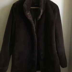 Jacka/Kappa i fuskpäls  - Mörkbrun fuskpälssydd jacka från Vero Moda.  I nyskick.