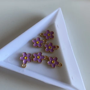 Berlocker  - 6 st super gulliga lila blomm berlocker! Purkets till sommaren, kan göras till öronhängen men kostar mer. 2 för 2kr.