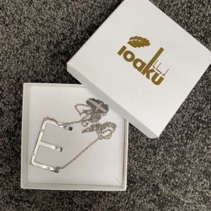 Halsband - Säljer ett superfint bokstavshalsband med ett ”E”. Från Ioaku och aldrig använt. Nypris 399kr