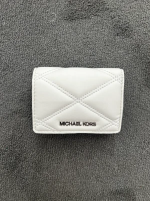Michael Kors  - Fick in ett antal av dessa riktigt trevliga plånböcker från Michael Kors. Plånboken har sex separata kort platser. Kontant ficka i mitten samt en ett litet utrymme för mynt och mindre saker.  Vid frågor skicka mer än gärna ett meddelande. 