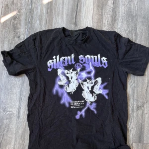 Svart T-shirt med tryck  - Svart T-shirt med lila tryck, använd men mycket fin