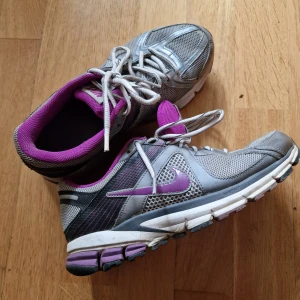 Nike lila silver 38,5 - Silver-lila nike, lite smutsiga då jag inte tvättat dem ännu - men inte speciellt slitna. Tvättas av i sulan innan frakt!!! Bra för både jobb, gång och löpning.