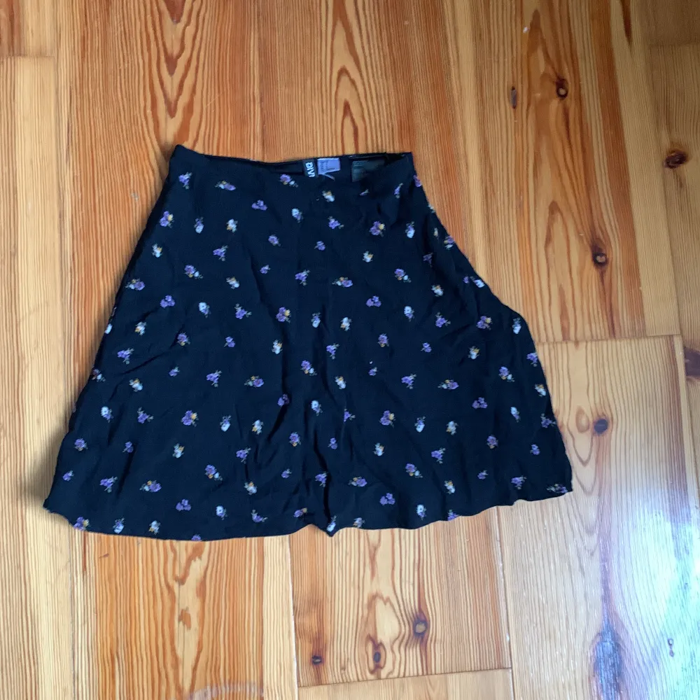 Det är en kort söt kjol från H&M. Den är svart med blommor.   Storlek 32. Kjolar.
