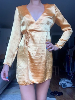 Helt ny omlottklänning - Fin klänning med prislapp kvar. Se sista bilden för att se både längden och en mer rättvis bild av hur färgen ser ut (orange)