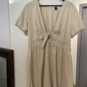 Klänning med knytdetalj - Jättefin klänning, använd en gång endast.