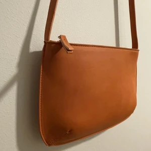 Lätt axelväska  - Vacker axelväska i orange färg, snygg till vardagen och festen 