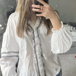Vit blus med detaljer - Säljer denhär vita blusen med svarta detaljer som är köpt på Plick💓bilden är lånad!