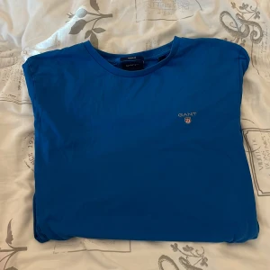 Gant t-shirt - En blå gant t-shirt. Tröjan är i storlek small men passar även medium. Den är i utmärkt skick och har inga hål eller andra defekter. Hör av dig för fler bilder eller frågor.