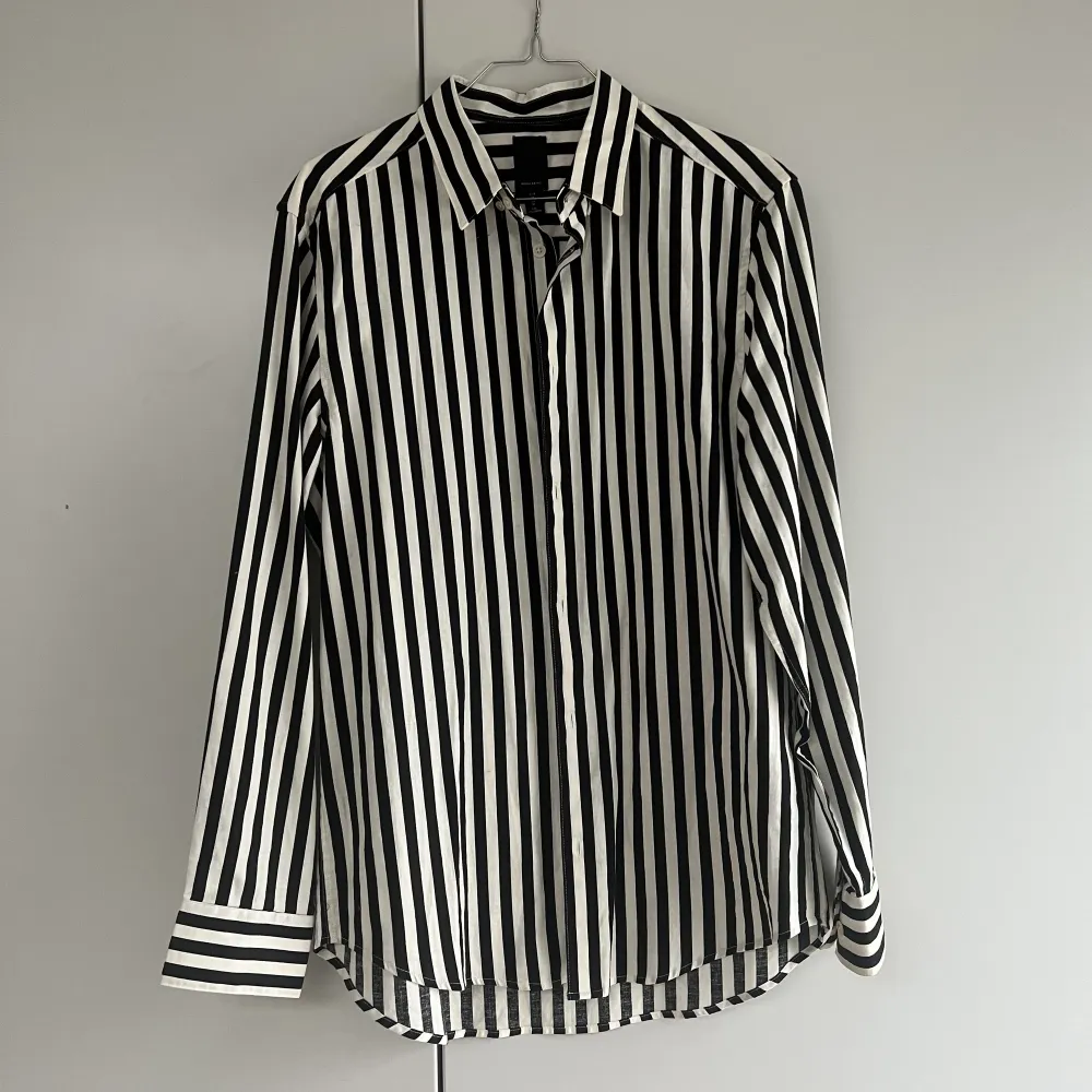 Svart och vit randig skjorta från H&M’s herravdelning. Regular fit. Har använt den som oversize skjorta över ett linne och ett par jeans typ. Kommer inte till användning längre . Skjortor.