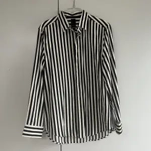Svart och vit randig skjorta från H&M’s herravdelning. Regular fit. Har använt den som oversize skjorta över ett linne och ett par jeans typ. Kommer inte till användning längre 