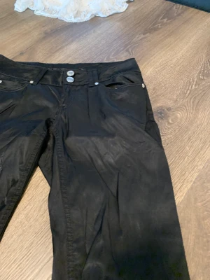 Glättade low waist byxor - Har en reva som är sydd i fram men som knappt syns. Strl 38
