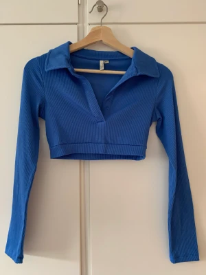 Långärmad blå topp - Långärmad marinblå topp från Nelly i croppad passform. Knappt använd, så fin! Storlek xs