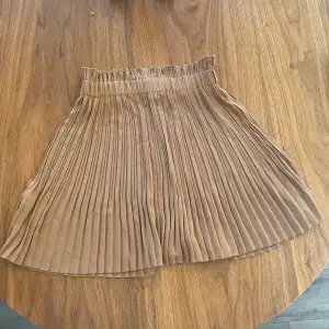 Brun plisserad kjol i strl 34   Från NA-KD 