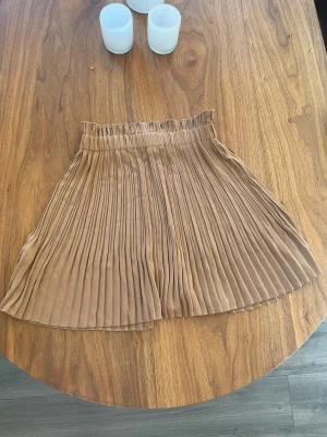 Gullig plisserad kjol - Brun plisserad kjol i strl 34   Från NA-KD 