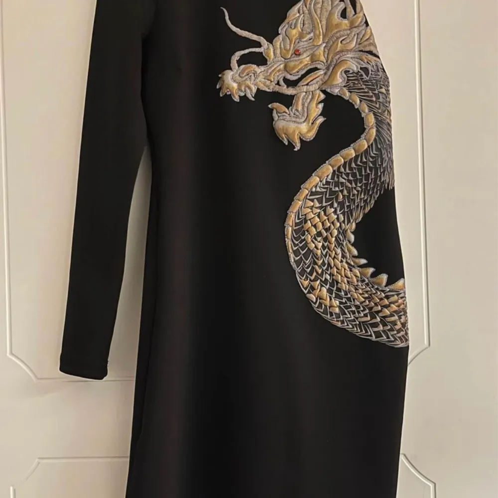Brand new offshoulder black dress with golden dragon. Bought in Spain for 149 EUR. Klänningar.