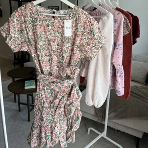 Blommig klänning - Superfin blommig klänning med knytning i midjan. Köpt från märket BYIC för ca 600kr. Aldrig använd, prislappen sitter kvar 🧡💐