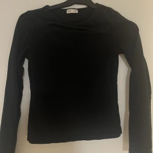 Svart långärmad tröja - Svart långärmad tröja med hål där framme. Super härlig tröja som används fåtal gånger. Den är i stl 146/152 men har också en annan likadan i 158/164 så gå o checka på den. Tröjan kostade ca 170kr och väntar på sitt nya hem.